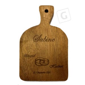 kleines Schneidbrett mit Gravur als Platzkarte bei einer Hochzeit. Inhalt: Name des Brautpaar, Datum, Ringe, Name des Gastes